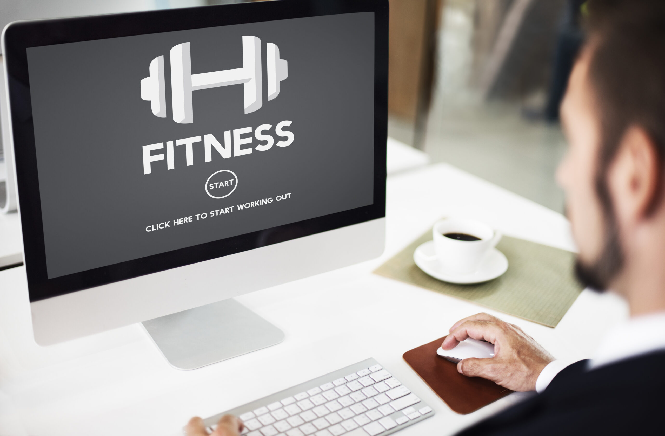 Man browsing a fitness blog start page on a computer, representing online fitness blogging.