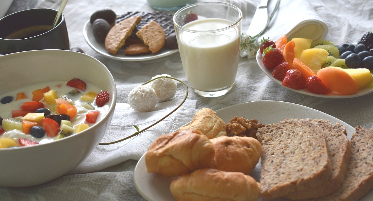 High-protein breakfast with yogurt, fruits, nuts, and whole-grain bread on a table