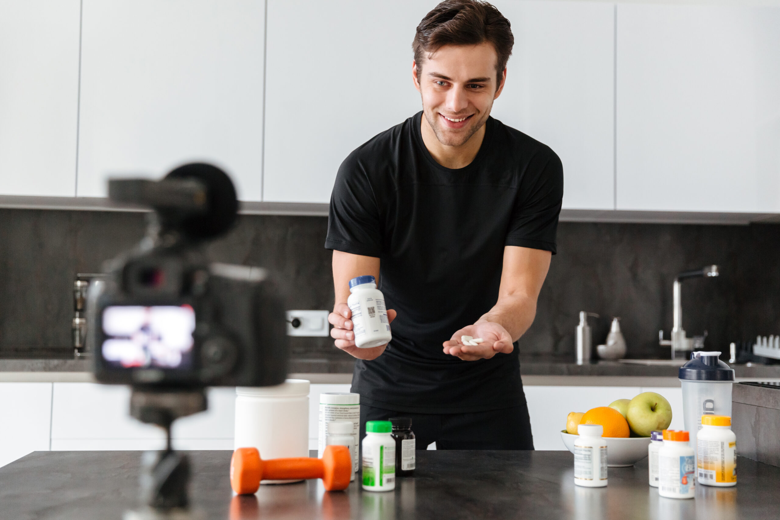 Man reviewing natural bodybuilding supplements in kitchen.